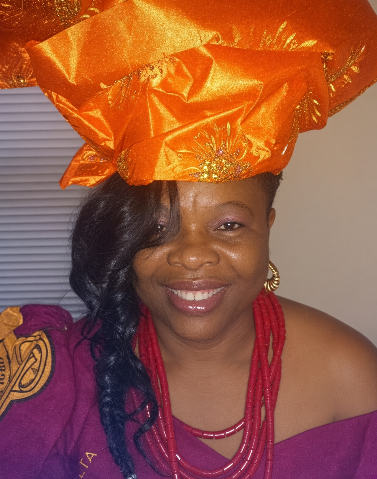 Gloria Nzenwa in an orange head tie and coral beads