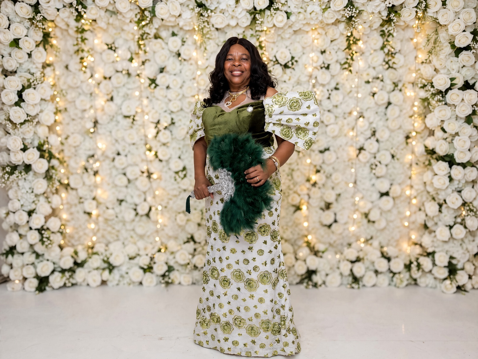 Gloria Nzenwa in white and green lace with a feather fan